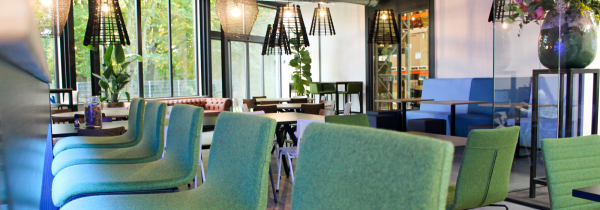 moderne kantine met ronde tafels, treinbanken en houten stoelen