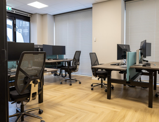 Moderne werkplekken met bureaustoelen en zit-sta bureaus met akoestische scheidingswanden