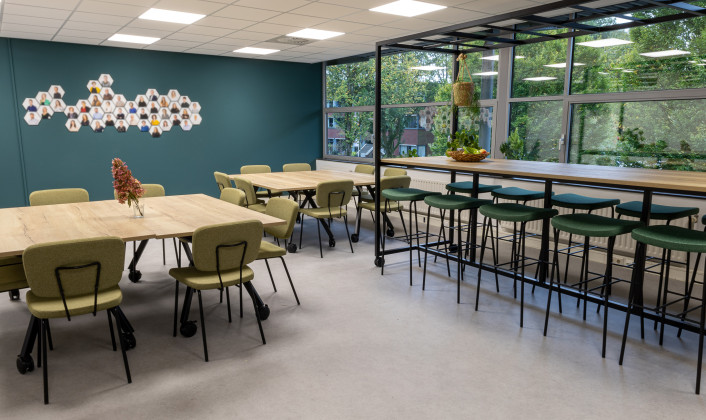 moderne kantine met hoge bartafel en krukken, kantinetafels met stoelen